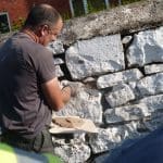 FIDEO: Gweithwyr dan hyfforddiant yn mynd i’r afael â morter calch