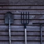 Rhos community garden in Wrexham. Image shows some gardening tools leaning up against a shed.