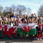 Image from St David's Day Parade of group of children holding a Welsh flag
